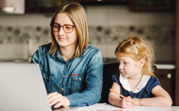 Woman and child working and looking at laptop