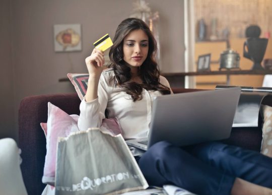 Young woman holding credit card online shopping on a notebook pc.