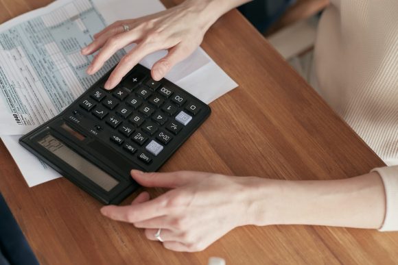 top down shot of person sat at desk with calculator