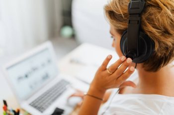 Woman with headset using notebook.